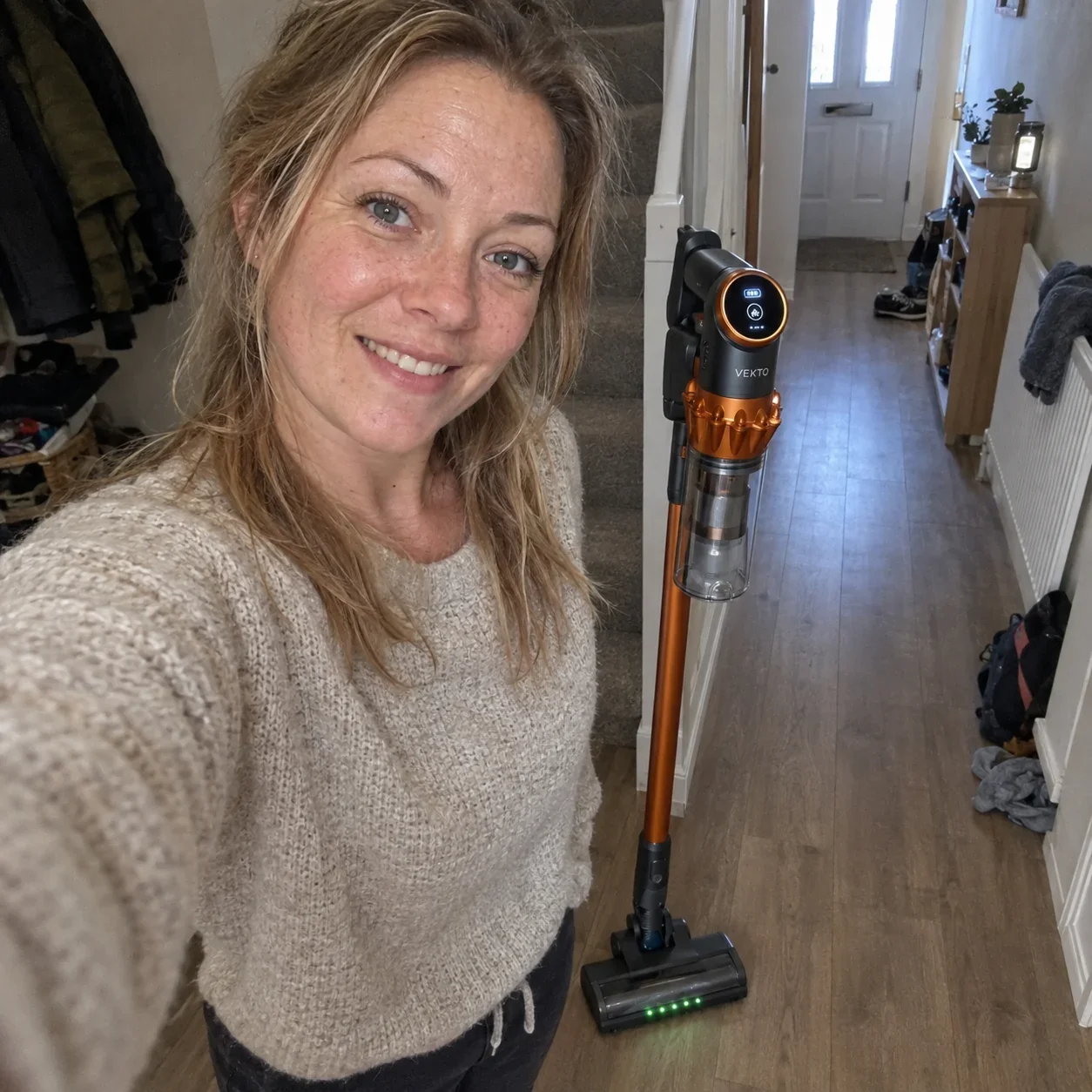 Emma in her hallway with the Vekto Vacuum V18 standing beside her